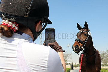 Doha  Reiterin fotografiert auf einem Turnier ihr Pferd mit ihrem Mobiltelefon