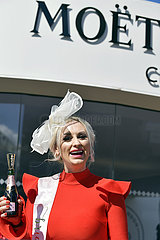 Aintree  Fashion on Ladies day: Woman with hat and a champagne bottle