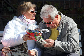 Hoppegarten  Deutschland  Mann liest in einem Heft mit einer Lupe