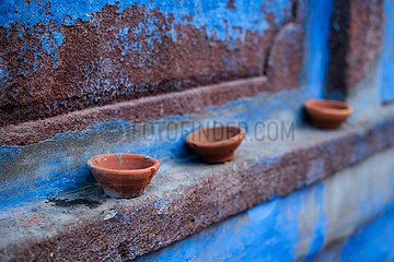 Oil Lamp Pooja Diya Lamp on blue house wall in Jodhpur  Rajasthan  India