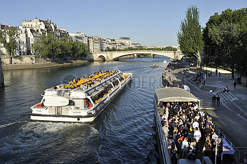 FRANCE. PARIS (75) A BATEAU-MOUCHE IS SAILING ON THE SEINE WHILE A RECEPTION IS TAKING PLACE ON A BOAT