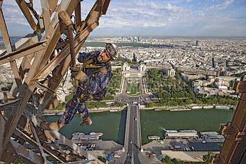 Paris (75) The estheticians of the Eiffel Tower (2010 restoration campaign). In make-up  an international team: 26 painter mountaineers who for a year had the mission of restoring the Iron Lady over an area of ??more than 250 000 m2 (the equivalent of 45 football stadiums!). Suspended at an altitude of 230 m under the third floor of the Eiffel Tower  the painter-mountaineer Arnaud Peltier applies a final coat of paint (dark brown) on the northwest face of the monument. In the background  the Quai Branly  the Pont d'Iena  the Seine  the gardens and the Trocadero Palace