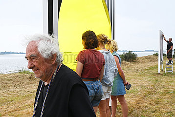 France. Brittany. Morbihan (56) Island of Arz. Bilherve. Daniel BUREN and a group of tourists in front of one of his works from the ephemeral exhibition Au detour des routes et des chemins by the famous visual artist  installed on the island until November 2023