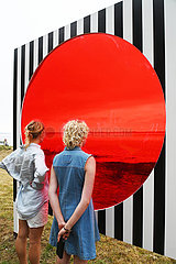 France. Brittany. Morbihan (56) Island of Arz. Bilherve. Tourists in front of one of the works of the ephemeral exhibition Au detour des routes et des chemins by the famous visual artist Daniel Buren  installed on the island until November 2023