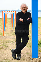 France. Brittany. Morbihan (56). Island of Arz. Pennero  the famous visual artist Daniel Buren in front of one of his works. Ephemeral exhibition Around the roads and paths installed on the island  until November 2023