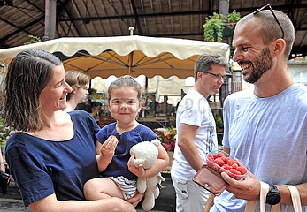 FRANCE. OCCITANY. LOT (46) FIGEAC. A YOUNG COUPLE AND THEIR CHILD ON MARKET DAY