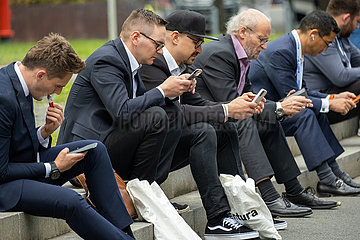 Deutschland  Hannover - Hannover-Messe  Geschaeftsleute aus unterschiedlichen Laendern sitzen konzentriert mit ihren smartfones