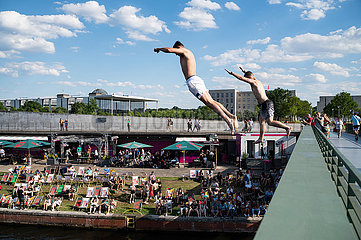 Berlin  Deutschland  Junge Maenner springen von Bruecke in die Spree mit Spreebogenpark und Capital Beach Bar