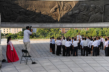 Pjoengjang  Nordkorea  Studenten am Monument zur Gruendung der Partei der Arbeit Koreas mit Bronzerelief