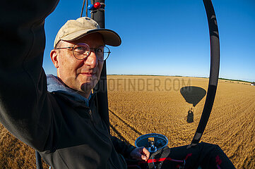 France  Essonne (91)  hot air balloon pilot preparing for landing near a wheat field in Beauce