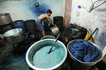 Mumbai  Indien  Arbeiter faerbt Stoffe in einem Metallbottich in einer Werkstatt im Elendsviertel Dharavi