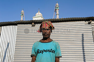 Mumbai  Indien  Portrait eines Mannes mit T-Shirt und dem Schriftzug Reporter im Elendsviertel Dharavi