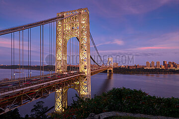 USA  New York City. Die beleuchtete George Washington Bridge über den Hudson River in der Abenddämmerung. Upper Manhattan