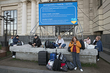 Lviv  Oblast Lviv  Ukraine - Ukrainische Kriegsfluechtlinge sitzen und stehen an einer Informationsanzeige fuer Fluechtlinge am Hauptbahnhof