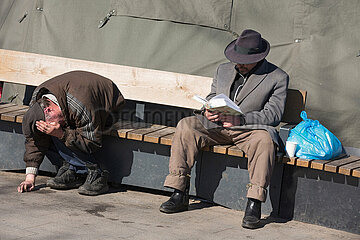 Lviv  Oblast Lviv  Ukraine - Zwei Obdachlose sitzen auf einer Bank auf dem Vorplatz zum Hauptbahnhof