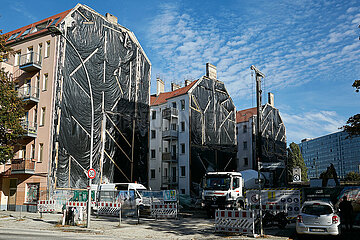 Berlin  Deutschland - Die Aussenwaende von drei Wohnhaeusern an einer Baustelle sind mit einer schwarzen Folie abgedeckt.