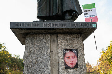 Berlin  Deutschland  Poster der Iranerin Mahsa Amini klebt am Sockel der Skulptur Der Rufer