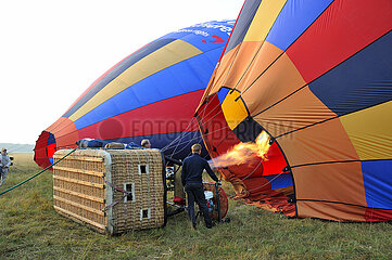 France. Seine-et-Marne (77) Loing Valley. Aerodrome of Moret-Episy. Hot air balloon flight with France Montgolfiere. Warm-up  inflation of the balloon and take-off