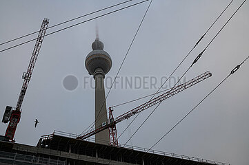 Berlin  Deutschland  Berliner Fernsehturm am Alexanderplatz im Nebel hinter einer Baustelle mit Baukraenen