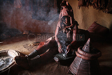 NAMIBIA  Kaokoland region  Opuwo  Himbas in his hut having covered his wedding clothes in a cloud of incense to purify the skin