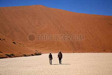NAMIBIA. Namib-Naukluft National Park  walkers in the Dead Vlei  at the foot of the Sossusvlei dunes