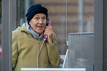 Deutschland  Bremen - Ruestige Rentnerin telefoniert an einer Telefonzelle der Deutschen Telekom