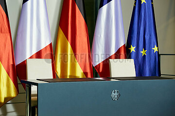 Berlin  Deutschland - Ein leerer Tisch mit zwei Stuehlen vor den Fahnen Frankreichs  Deutschlands und der EU im Kanzleramt.
