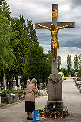 Kroatien  Zagreb - multikonfessioneller Zentralfriedhof Mirogoj  angelegt 1876 (k.u.k.-Monarchie) -1929  alte Frau bekreuzigt sich vor Jesusstatue