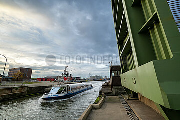 Deutschland  Bremerhaven - Ausflugsboot fuer Hafenrundfahrt passiert hochgezogene Zugbruecke an einer Schleuse