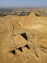 Egypt. Cairo. Gizeh (or Giza) Aerial view to the west of the city: in the foreground  the three pyramids of the queens of Mykerinos. In the background  the pyramids of Mykerinos  Khephren and Kheops. To the right of the latter  the three small pyramids of the queens of Cheops. All are from the IVth dynasty. In the background  the city of Giza (western suburb of Cairo)