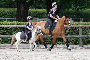 Gestuet Graditz  Maedchen reiten mit ihren Ponies auf einem Reitplatz