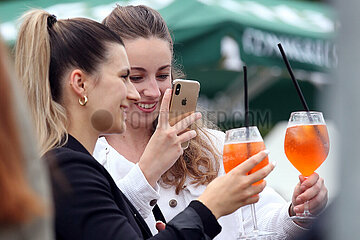 Leipzig  Deutschland  junge Frau fotografiert mit ihrem Mobiltelefon die Drinks von sich und ihrer Freundin