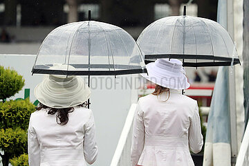 Hamburg  Deutschland  Frauen mit Hueten unter ihren Regenschirmen