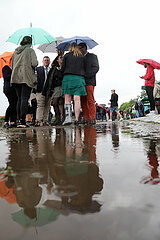 Leipzig  Deutschland  Menschen stehen bei Schlechtwetter unter ihren Regenschirmen