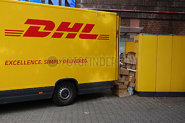 Berlin  Deutschland  Pakete stehen zwischen einem Lieferwagen der DHL und einer Paketabholstation