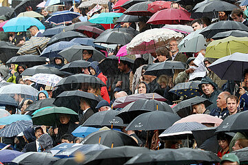 Paris  Frankreich  Menschen stehen bei einer Freiluftveranstaltung im Regen unter ihren Regenschirmen