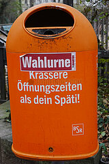 Berlin  Deutschland  Sticker Wahlurne klebt auf einem Strassenmuelleimer der BSR mit der Aufschrift Krassere Oeffnungszeiten als dein Spaeti