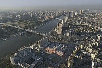 Egypt. Cairo. Aerial view of downtown modern Cairo from the right bank of the Nile. In the center foreground  the famous Egyptian Museum (in red brick) now houses most of the remains of Egyptian civilization. To the left of the museum  the Arab League building and the Nile Hilton Hotel. In the background  the island of Zamalek