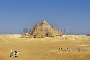 Egypt. Cairo. Gizeh (or Giza). From the desert  west of Cairo  the famous view of the nine pyramids: in the foreground  the three small pyramids of the queens of Mykerinos. Behind  the pyramids of Mykerinos  Khephren and Kheops. To the right of the latter  the three small pyramids of the queens of Cheops. All are from the IVth dynasty. In the background on the right  the city of Cairo