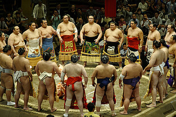 Sumo wrestlers in their decorated ceremonial apron (kesho-mawashi) gather in a circle around the gyoji (referee) in the dohyo-iri. Grand Tournament of Sumo. Kokugikan arena. Sumida district. City of Tokyo. Kanto province. Honshu island. Japan.