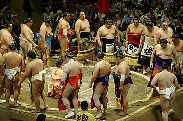 Sumo wrestlers in their decorated ceremonial apron (kesho-mawashi) gather in a circle around the gyoji (referee) in the dohyo-iri. Grand Tournament of Sumo. Kokugikan arena. Sumida district. City of Tokyo. Kanto province. Honshu island. Japan.