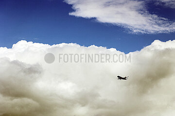 Hannover  Deutschland  Silhouette eines Flugzeugs vor einer grossen Wolke