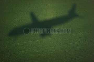 Zuerich  Schweiz  Silhouette eines Flugzeugs im Landeanflug zeichnet sich auf einem Acker ab
