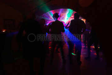 Werl  Deutschland  Menschen tanzen auf einer Party im Laserlicht