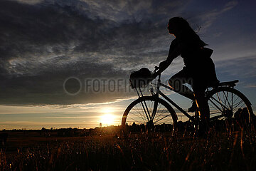 Berlin  Deutschland  Silhouette einer Fahrradfahrerin bei Sonnenuntergang