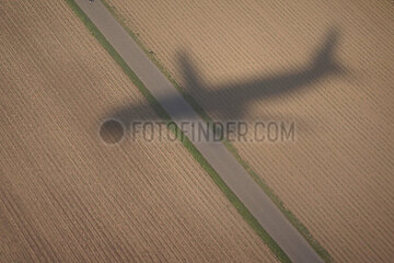 Zuerich  Schweiz  Silhouette eines Flugzeugs im Landeanflug zeichnet sich auf einem Acker ab
