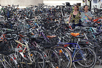 Zuerich  Schweiz  Frauen suchen auf einem Fahrradparkplatz nach ihren Raedern