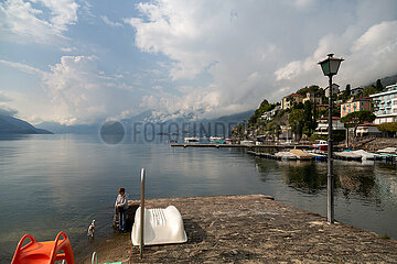 Schweiz  Ascona - Frau mit Hund an der Uferpromenade am Lago Maggiore