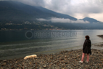 Schweiz  Ascona - Herbstliche Stimmung  Frau mit Hund  Morgendaemmerung am Lago Maggiore
