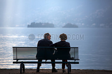 Schweiz  Ascona - Rentnerpaar auf Sitzbank am am Lago Maggiore